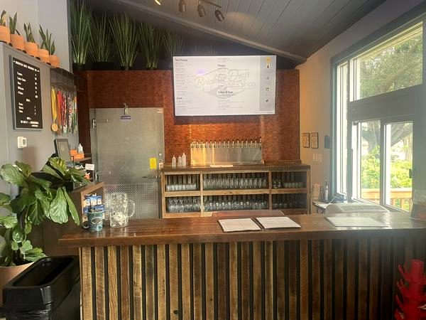 Indoor taphouse with a wood counter and TV
