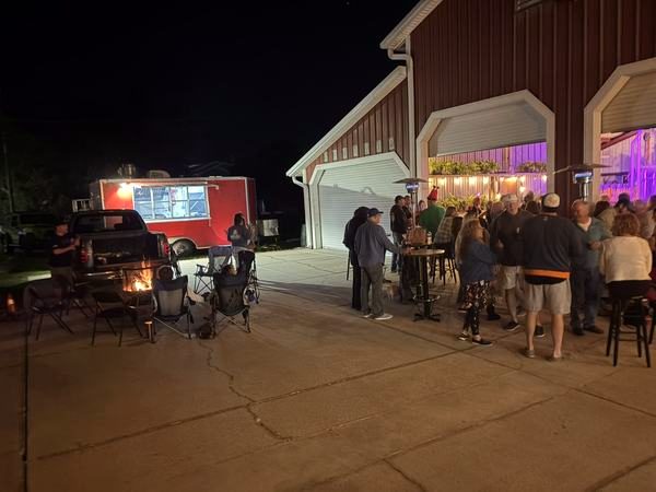Night crowd outside the garage doors with a red food trailer