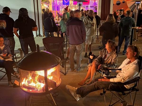 Fire pit glowing on a busy night
