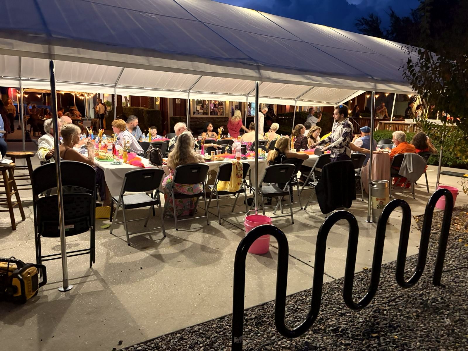 Reception tables under a tent lit with string lights