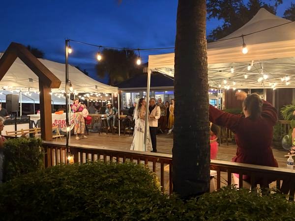Evening on the deck under string lights and tents